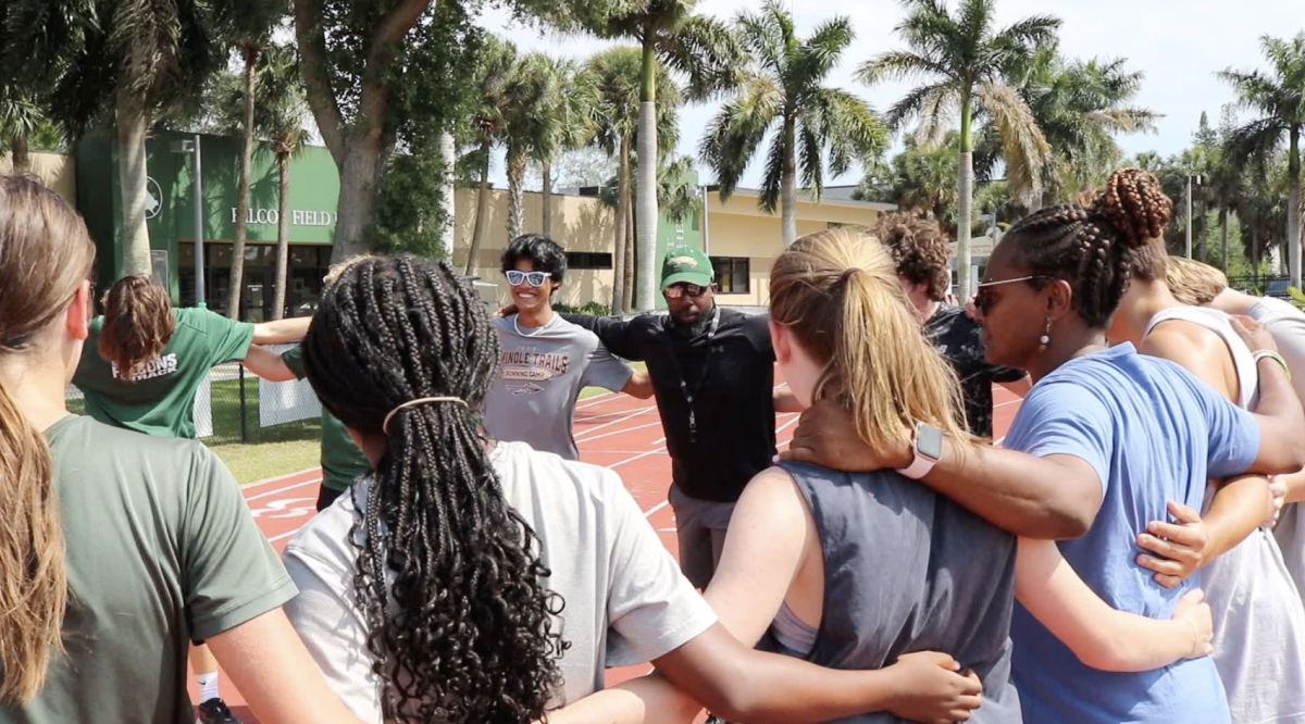 Coach Brown gathers with the track team for a pre-practice meeting.